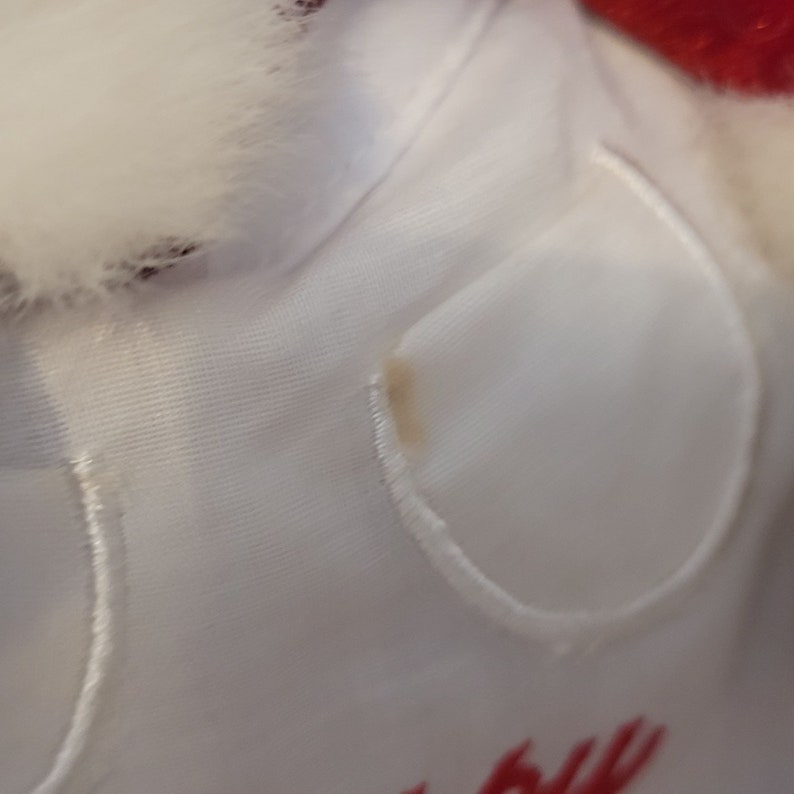K&ouml;nnte beinhalten: Wei&szlig;er Stoff mit einem kleinen braunen Fleck. Der Stoff hat einen wei&szlig;en Saum an den R&auml;ndern.