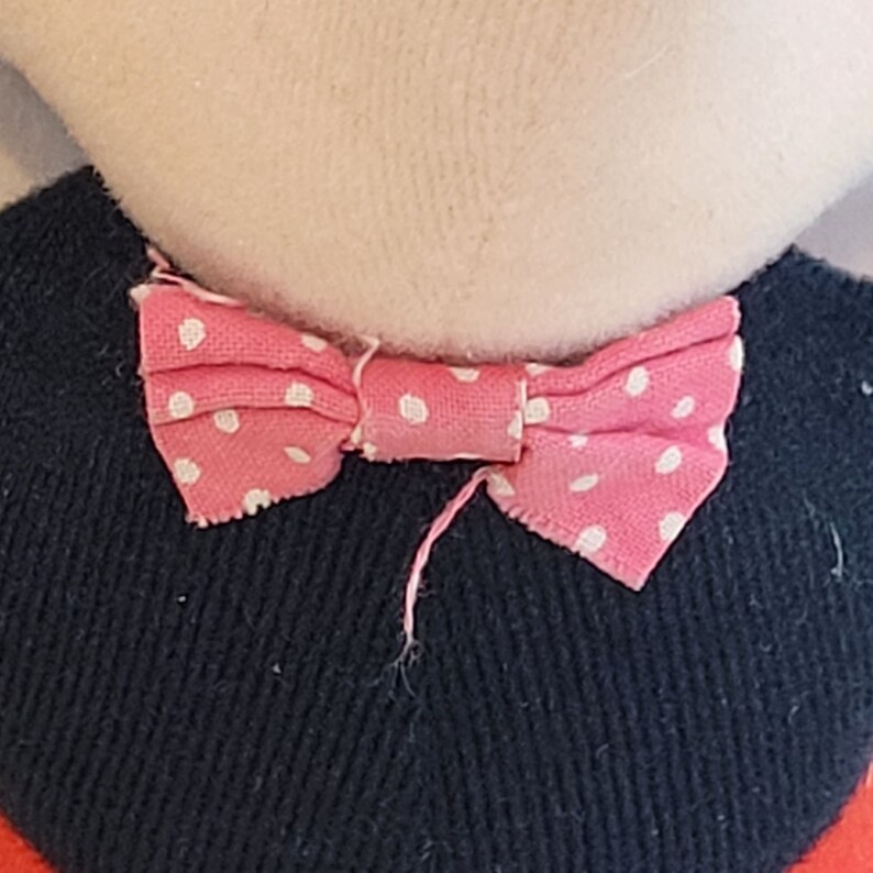 Peut inclure: Un n&oelig;ud papillon rose &agrave; pois blancs, nou&eacute; autour d'un cou.