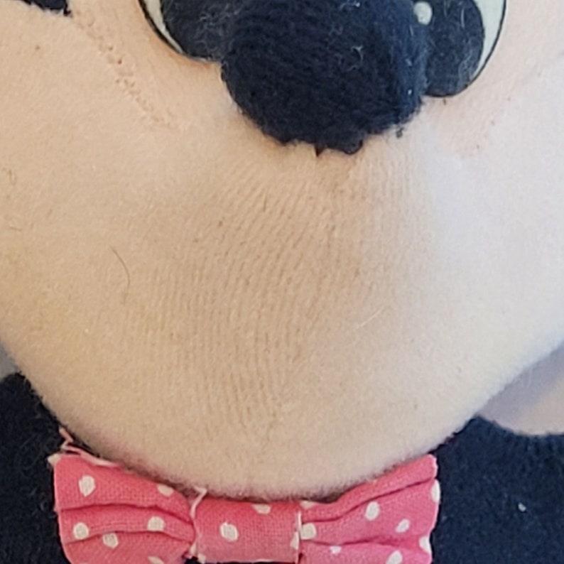 Peut inclure: Un jouet en peluche avec un n&oelig;ud papillon &agrave; pois rose et blanc. Le jouet a un nez noir et des yeux noirs.