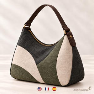 Può includere: Una borsa a mano in stile hobo con un design a blocchi di colore in pannelli di tessuto grigio antracite, verde oliva e crema. La borsa include un manico marrone scuro fissato con hardware color ottone, una cerniera e il testo AmySewingdesign.