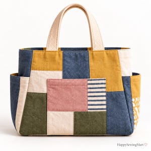 Puede incluir: Un bolso tote de patchwork con paneles rectangulares en amarillo mostaza, azul denim, verde oliva, crema y rosa empolvado. El bolso incluye un bolsillo central rosa, una sección a rayas azul marino y blancas, dos asas y bolsillos laterales.