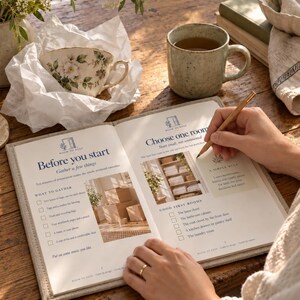 May include: An open workbook titled Room to Keep with printed text and images on pages. The left page is headed Before you start and the right page is headed Choose one room. A wooden pencil is held over the right page. The book has a light beige fabric cover.