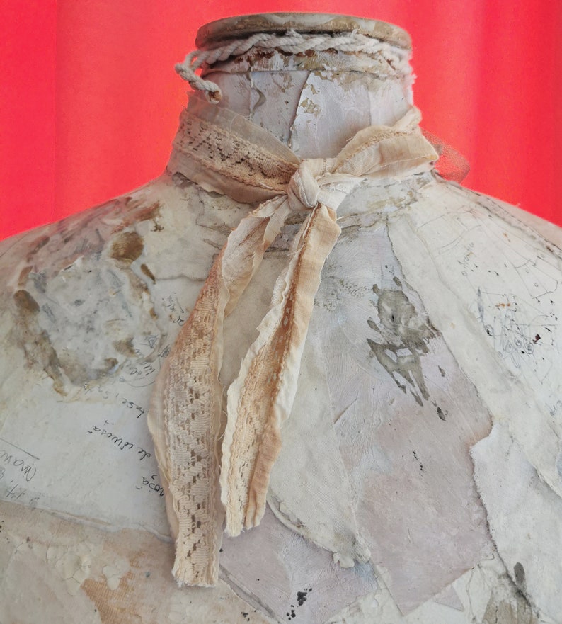 Peut inclure: Une bouteille en c&eacute;ramique blanche avec un ruban en dentelle nou&eacute; autour du cou. La bouteille est d&eacute;cor&eacute;e de couches de papier et a un aspect vieilli et vintage.