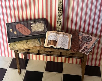 May include: A miniature wooden table with a gold obelisk, a book titled "The Egyptian Echo", a small wooden box with a leather sandal inside, and a map on top. The table is on a black and white checkered floor.