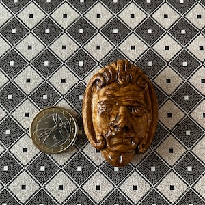 Dollhouse miniature reproduction of an ancient greek mask