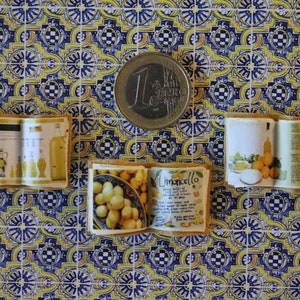 May include: Three miniature recipe books with yellowed pages and brown covers. The books are open to show recipes for limoncello, a lemon liqueur. The books are on a patterned surface with yellow, blue, and white tiles.
