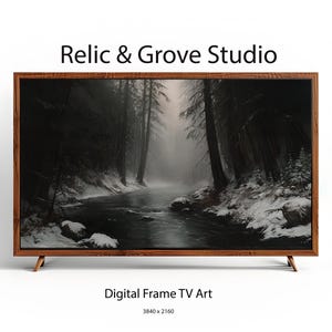 Op de afbeelding: Een televisie met een houten lijst toont digitale kunst van een donker, besneeuwd boslandschap met een rivier. De tekst Relic & Grove Studio, Digital Frame TV Art en 3840 x 2160 is zichtbaar boven en onder het televisiescherm.