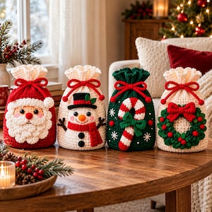 Könnte beinhalten: Vier gehäkelte Geschenktüten mit Kordelzug und weihnachtlichen Motiven. Die erste ist rot mit einem Weihnachtsmann-Gesicht. Die zweite ist cremefarben mit einem Schneemann. Die dritte ist grün mit einer Zuckerstange. Die vierte ist cremefarben mit einem grünen Kranz.