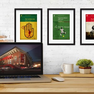 May include: Three framed prints with a sports theme. The prints feature a hand with an eye, a soccer player, and a soccer player with a crown. The prints are hanging on a white brick wall above a laptop computer.