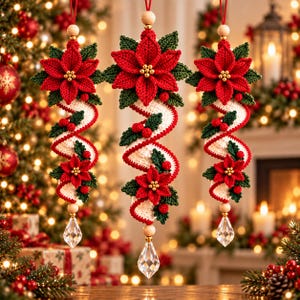 May include: Three hanging Christmas ornaments featuring crocheted red poinsettia flowers, green leaves, and small red berries attached to a spiralling white crocheted ribbon. Each ornament is topped with a wooden bead and finished with a clear crystal.