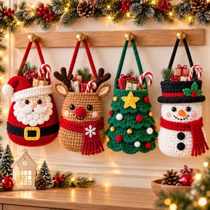 May include: Four crocheted Christmas hanging baskets shaped like Santa Claus, a reindeer, a Christmas tree, and a snowman. Each basket features a handle, festive colours, and small gift boxes inside. They are suspended from a wooden wall rack.