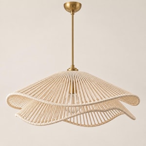 May include: A pendant light fixture featuring a wide, wavy-edged shade constructed from cream-colored rope wrapped around a frame. The fixture includes a central brass-toned metal rod and a matching circular ceiling canopy mount.