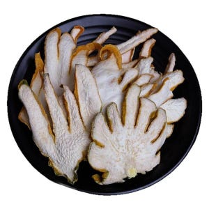 May include: A collection of dried, sliced Buddha's hand citron fruit pieces arranged on a round, black plate. The slices feature a textured, white interior flesh with a thin, yellow-green rind, showcasing the distinct finger-like segments.
