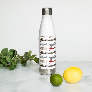 May include: A white stainless steel water bottle with a metallic silver cap, featuring a repeating pattern of various vintage and modern military aircraft illustrations in shades of red, brown, grey, and black printed around the center.