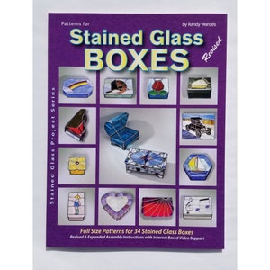 May include: A book titled "Stained Glass Boxes" with a purple cover and a collection of stained glass box designs. The book includes full-size patterns for 34 stained glass boxes and revised and expanded assembly instructions with internet-based video support.