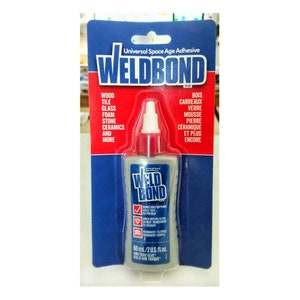 May include: A bottle of WeldBond Universal Space Age Adhesive. The bottle is clear and has a red cap. The label is blue and white and says "WeldBond" in large red letters. The label also says "Bonds Most Anything" and "Dries Crystal Clear". The bottle is 60 ml or 2 US fl oz.