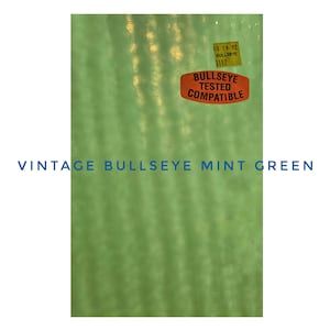 May include: Vintage mint green glass with the text "VINTAGE BULLSEYE MINT GREEN". The glass has a textured surface and two stickers: one yellow with "10 19 92 BULLSEYE 3112" and one orange with "BULLSEYE TESTED COMPATIBLE".