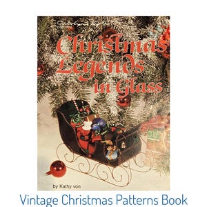 May include: A vintage Christmas patterns book titled "Christmas Legends in Glass" by Kathy von. The cover features a festive scene with a sleigh filled with gifts, ornaments, and a Christmas tree background.