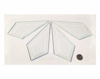 May include: Five clear glass diamond-shaped pieces, each with a beveled edge, arranged in a starburst pattern. A US quarter is included for scale.