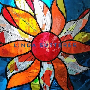 May include: A stained glass artwork depicting a stylized flower with orange, red, yellow, and white petals. The center of the flower is a red circle. The background is blue. The text "GLASSCOMPOSITIONS" and "LINDA SUTTERER" are visible in the image.