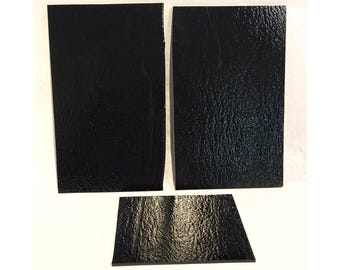 May include: Three rectangular black panels with a textured surface. The two larger panels measure 5 inches by 8 inches, with the left panel featuring a slight rolled edge and the right panel having clean cut edges. The smaller center panel measures 4 inches by 5 inches.