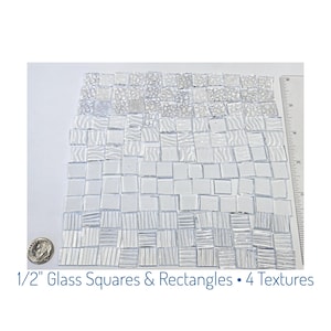 May include: A collection of clear glass mosaic tiles, each measuring 1/2 inch, with four different textured surfaces. The tiles are arranged on a white surface, with a ruler and a coin for size reference. The text reads "1/2" Glass Squares & Rectangles • 4 textures."
