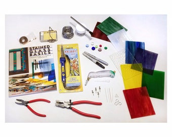 May include: A stained glass starter kit including a Stained Glass Basics instructional book, a Hakko FX-601 soldering iron, red-handled pliers, a glass cutter, various colored glass sheets, solder wire, flux, markers, and small metal hardware components.