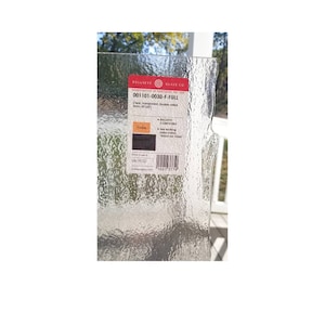 May include: A close-up of a clear glass sheet with a textured surface. The sheet has a label that reads "Bullseye Glass Co." and "001101-0030-F-FULL". The label also includes the text "Cleat Transparent Double rolled 3mm, 30"x30".