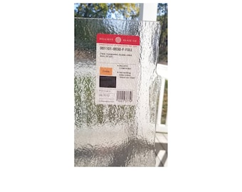 May include: A close-up of a clear glass sheet with a textured surface. The sheet has a label that reads "Bullseye Glass Co." and "001101-0030-F-FULL". The label also includes the text "Cleat Transparent Double rolled 3mm, 30"x30".
