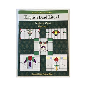 May include: A stained glass pattern book titled "English Lead Lites I" by Vincent Dimas, Volume 1. The cover features stained glass designs in red, green, yellow, and purple on a dark green background with a fleur-de-lis pattern.