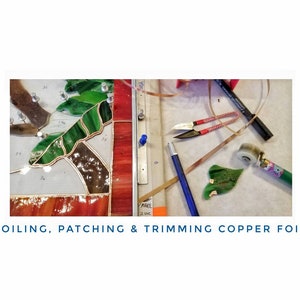 May include: A close-up of a stained glass project in progress. The image shows a green leaf, copper foil, and tools used for foiling, patching, and trimming copper foil.