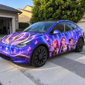 May include: A Tesla vehicle featuring a custom purple and blue wrap with a K/DA pop group graphic on the side, a microphone illustration on the hood, and floating musical notes. The car has black multi-spoke wheels and a sleek aerodynamic design.