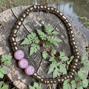 Braccialetto MOM con perline, perline dorate, perline con lettere rosa, elastico, 15-16,5 cm.