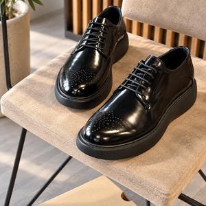 May include: A pair of black glossy oxford shoes featuring a rounded toe with decorative perforated detailing, black laces, and a thick, solid black platform sole. The shoes have a smooth, polished finish and a structured, low-top silhouette.