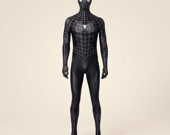 May include: A full-body black spandex bodysuit featuring a white web pattern across the head, chest, and lower legs. The suit includes a white spider emblem on the chest and white eye lenses, covering the wearer from head to toe.