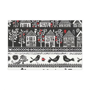 May include: A rectangular fabric print featuring horizontal bands of black, white, and red. The top section displays stylized houses and trees. The middle section shows a geometric pattern. The bottom section depicts birds and floral motifs.
