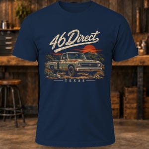 K&ouml;nnte beinhalten: Ein marineblaues Kurzarm-T-Shirt mit einer Grafik eines alten Pick-ups in einer W&uuml;stenlandschaft bei Sonnenuntergang. Der Text 46 Direct ist in wei&szlig;er Schreibschrift &uuml;ber dem Fahrzeug gedruckt, darunter steht das Wort TEXAS.