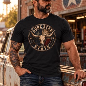 Peut inclure: Un t-shirt noir &agrave; manches courtes avec un motif circulaire sur la poitrine. Le design comprend un cr&acirc;ne de longhorn, le texte LONE STAR STATE et un drapeau du Texas en arri&egrave;re-plan avec deux &eacute;toiles, le tout dans un style vieilli.