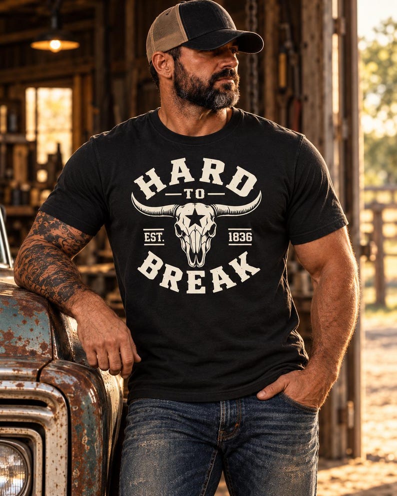 May include: A black short-sleeve t-shirt featuring a white graphic of a longhorn skull with a star on the forehead. The text reads HARD TO BREAK with EST. 1836 printed below the skull. The design is centered on the chest of the garment.