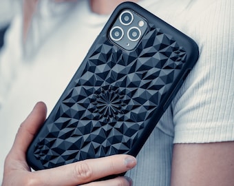 May include: A black phone case with a geometric pattern and a raised camera bump. The case is made of a durable material and has a sleek design.