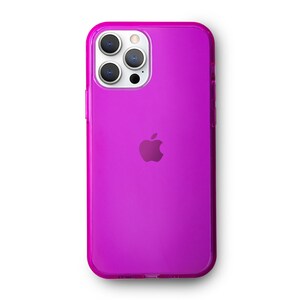 May include: A clear, bright pink phone case with a raised Apple logo. The case has a cutout for the camera lens and a clear back.