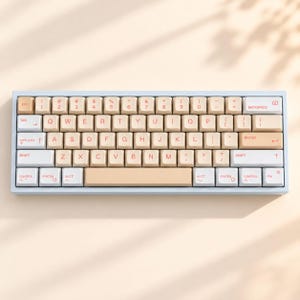 May include: A compact mechanical keyboard featuring a light blue frame and a color-blocked keycap set in shades of beige, cream, and white. The keys display a standard QWERTY layout with red lettering for letters, numbers, and symbols.