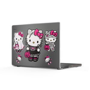 Può includere: Una custodia per laptop grigio scuro con cinque adesivi di Hello Kitty a tema Halloween. I disegni includono Hello Kitty vestita da fantasma, mostro di Frankenstein e mummia, insieme a due figure di gatti più piccole, tutte con fiocchi rosa.