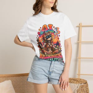 May include: A white short-sleeve t-shirt featuring a colorful graphic print of a robotic figure with a flower crown, making a peace sign. The design includes the text AI HALLUCINATING REALITY in bold letters, surrounded by flowers and smoke.
