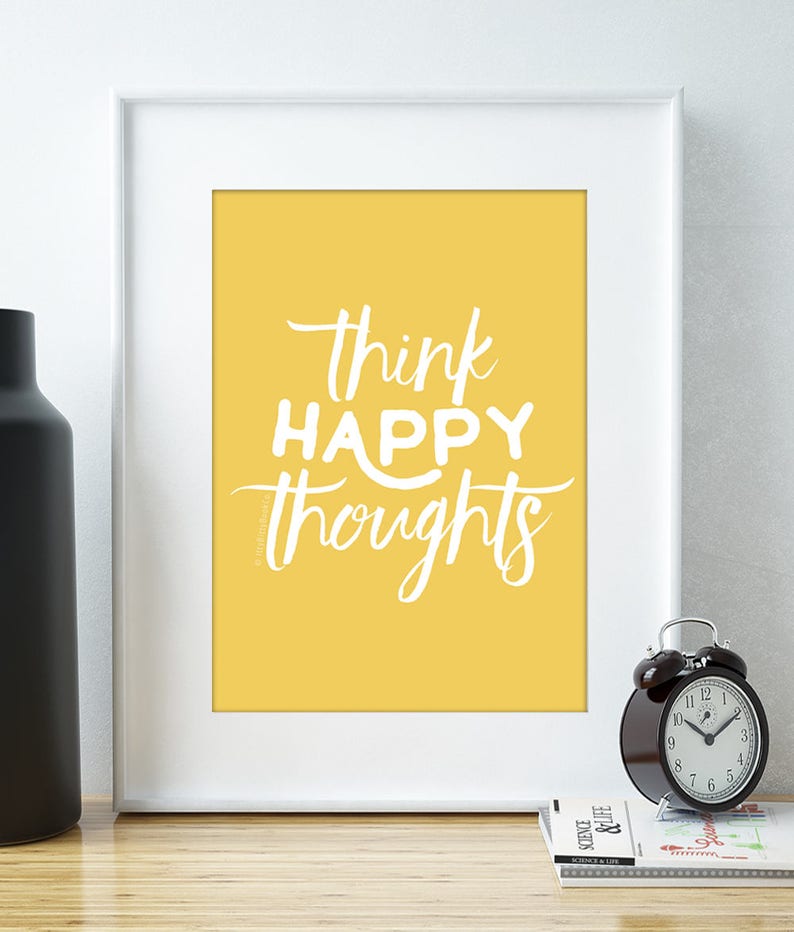May include: A yellow framed print with white text that reads "think happy thoughts".