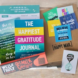 Bundel wellness-briefpapier: 30 dagen dankbaarheidsdagboek, weekplanner met gewoontetracker, offertekaarten, gegraveerde pen en havermelkchocolade.
