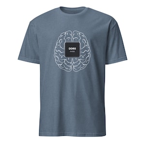 May include: A heathered blue short-sleeve t-shirt featuring a white line-art graphic of a human brain. Centered on the brain graphic is a black square computer chip icon with the white text DDR5 and 64GB printed clearly on its surface.