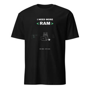 May include: A black short-sleeve t-shirt featuring the white text I NEED MORE < RAM >. Below the text is a graphic of a cat wearing glasses at a laptop with code snippets, a coffee mug, and the text MORE MEMORY. BETTER IDEAS. printed in white.