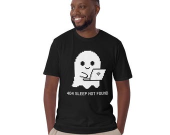 May include: A black short-sleeve t-shirt featuring a white pixelated graphic of a ghost using a laptop. Below the ghost, the text reads 404 SLEEP NOT FOUND in a white pixelated font. The shirt has a crew neckline and a standard fit.