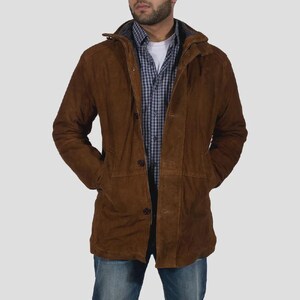 Peut inclure: Une veste en daim marron avec une capuche, dotée d'une fermeture à boutons sur le devant et de deux poches latérales. La veste est portée sur un t-shirt blanc et une chemise à carreaux bleus et blancs, avec un jean bleu.